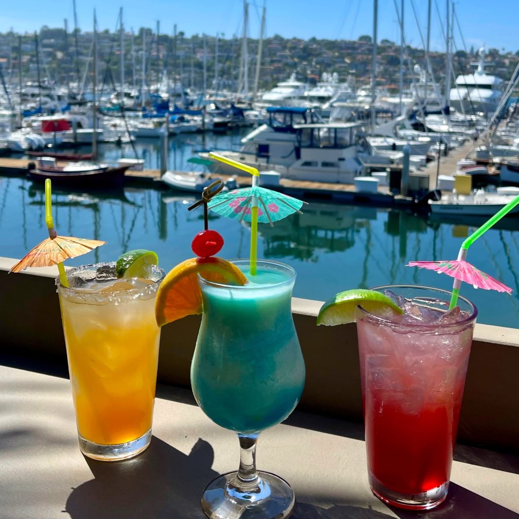 three tropical coktails in front of marina