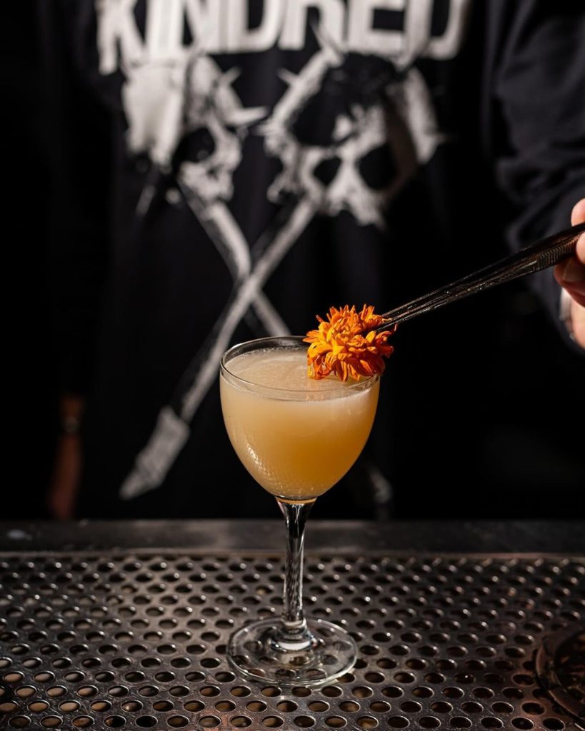 Orange Cocktail with Flower being put in it